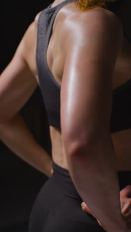 Vertical-Video-Close-Up-Studio-Shot-Showing-Back-Of-Mature-Woman-Wearing-Gym-Fitness-Clothing-Doing-Stretching-Exercises